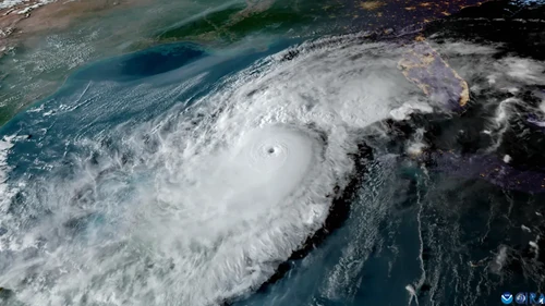 Satellite image of a massive hurricane with a clearly defined eye approaching the Gulf Coast, with visible cloud bands...